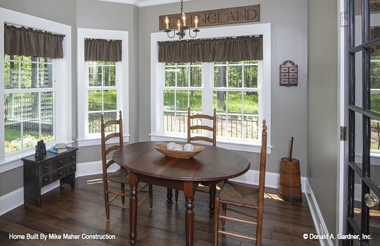 Breakfast nook with a round dining set and bay window dressed in classy valances.