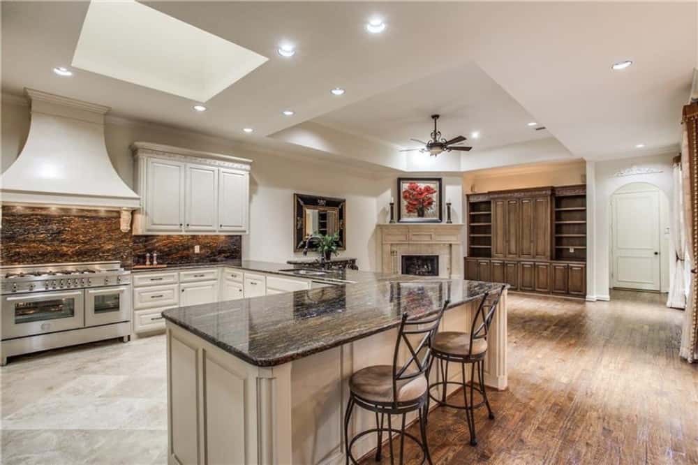 The kitchen has white cabinetry, a breakfast bar, and a skylight.