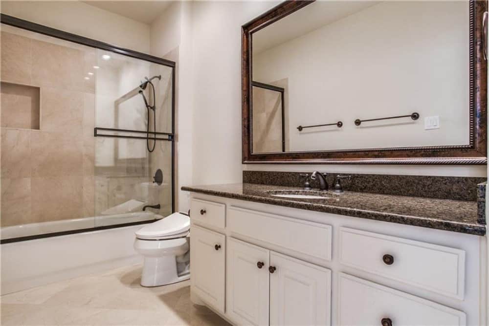 This bathroom is equipped with a sink vanity, a toilet, and a tub and shower combo.