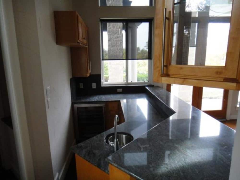 The kitchen peninsula is fitted with a small sink and a raised eating bar.
