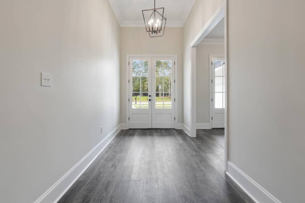 Foyer with a french entry door and lantern pendant hanging from the regular white ceiling.