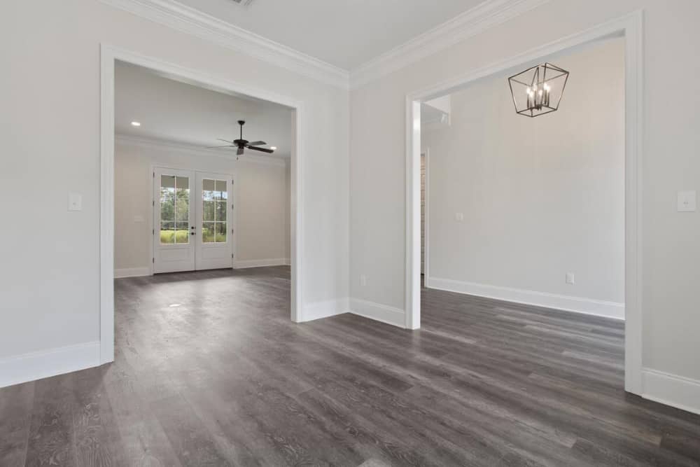This is the flex room with hardwood flooring and light beige walls lined with white moldings.