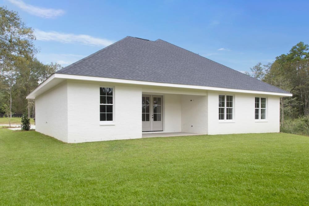 Rear exterior view with a covered porch and a french door leading to the home's living space.