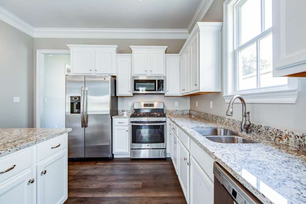 The kitchen includes a double bowl sink paired with a gooseneck faucet.