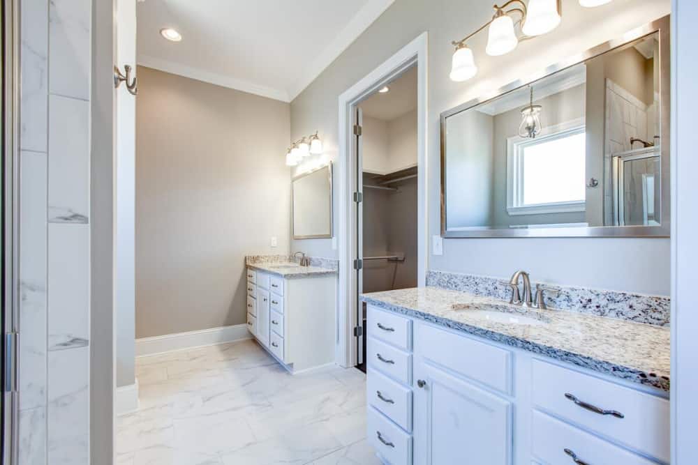 The primary bathroom features his and her sink vanities flanking the walk-in closet.