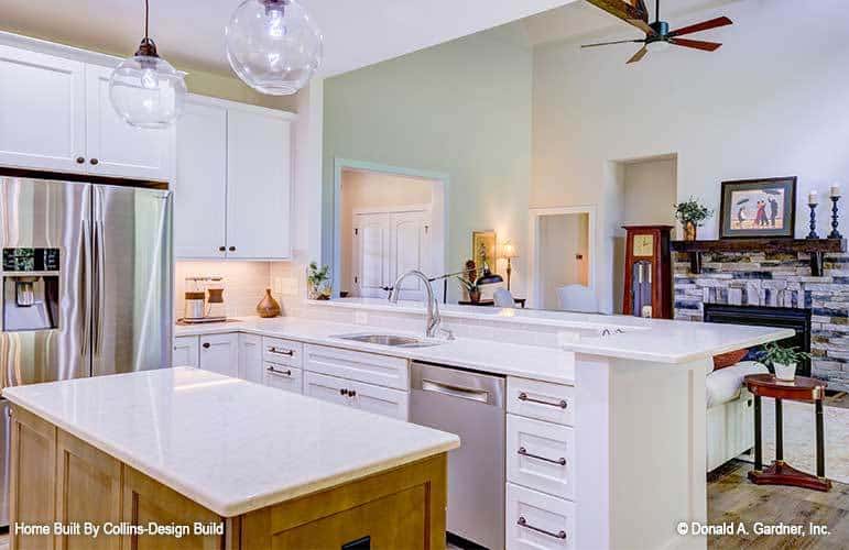 The kitchen peninsula is fitted with white drawers, a dishwasher, and a double bowl sink.