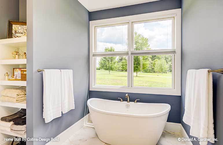 A freestanding tub placed under the picture window completes the primary bathroom.