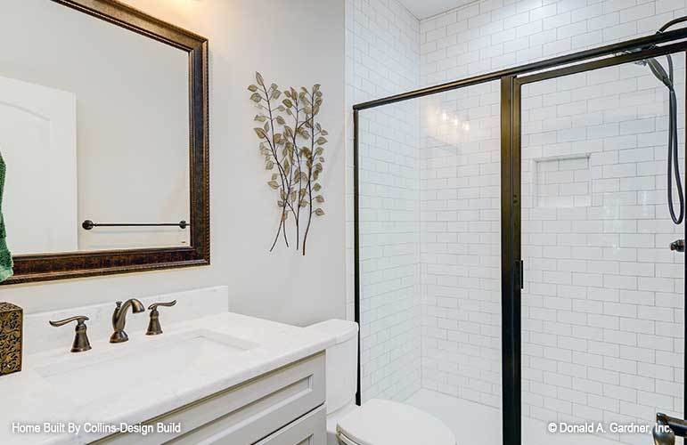 This bathroom is equipped with a single sink vanity, a toilet, and a walk-in shower.