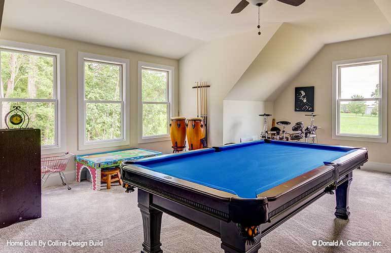 Bonus room with a vaulted ceiling, a billiards table, a drum set, kid's table, and plenty of windows.