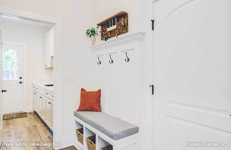 Mudroom with coat hooks and a built-in bench with storage baskets underneath.