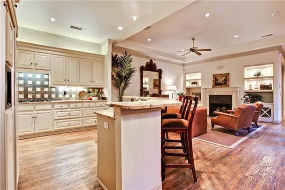 The kitchen includes a curved island integrated with a raised eating bar.