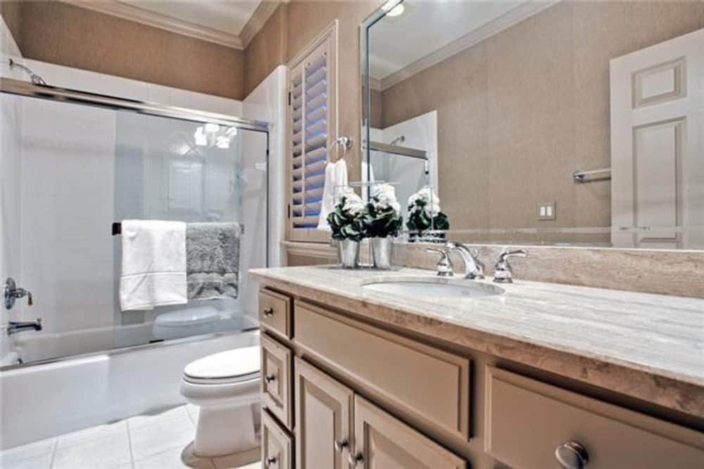 This bathroom offers a sink vanity, a toilet, and a tub and shower combo.