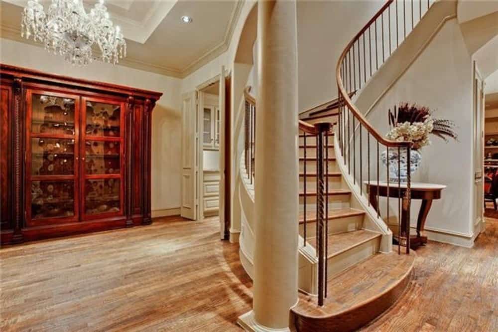 This is the dining area with a large display cabinet and a tray ceiling adorned with a crystal chandelier.