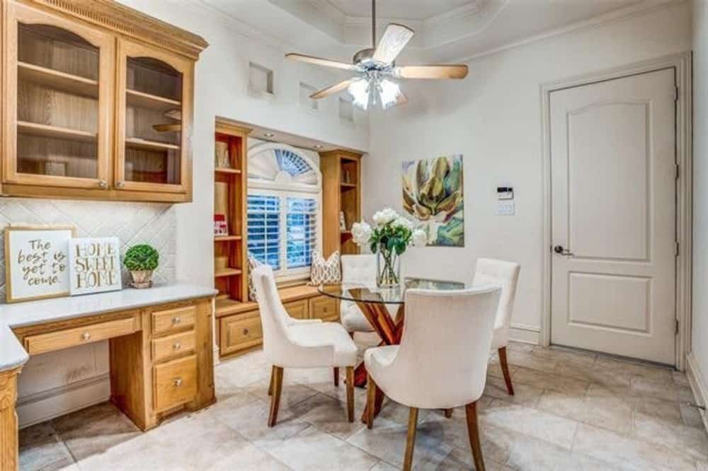 Breakfast area with a round dining set, a built-in desk, and a window seat.
