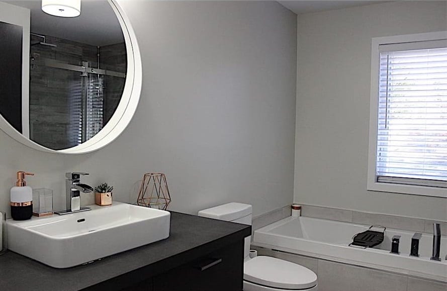 This bathroom offers a sink vanity, a toilet, and a deep soaking tub.