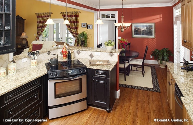 Kitchen with wooden cabinetry, granite countertops, and a peninsula with a raised eating bar.