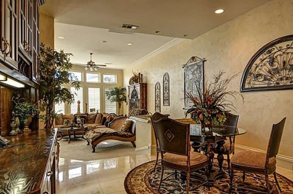 Breakfast nook with a round dining set and cushioned chairs over a round patterned rug.