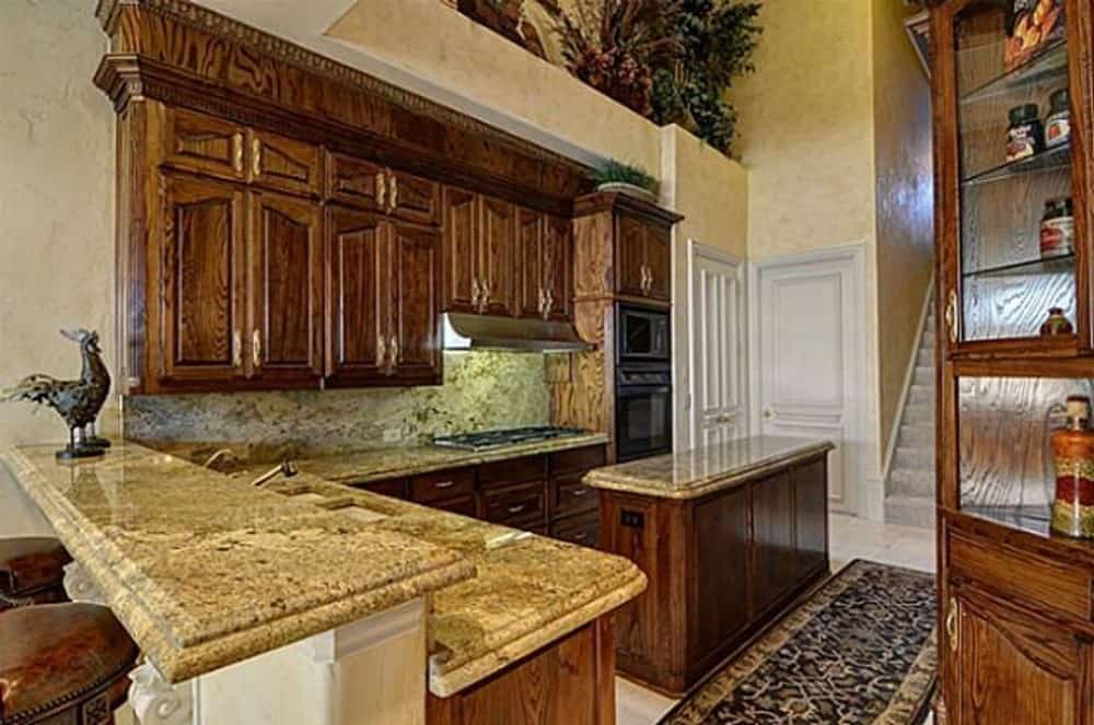 Kitchen with granite countertops, a center island, and a peninsula with a raised snack bar.