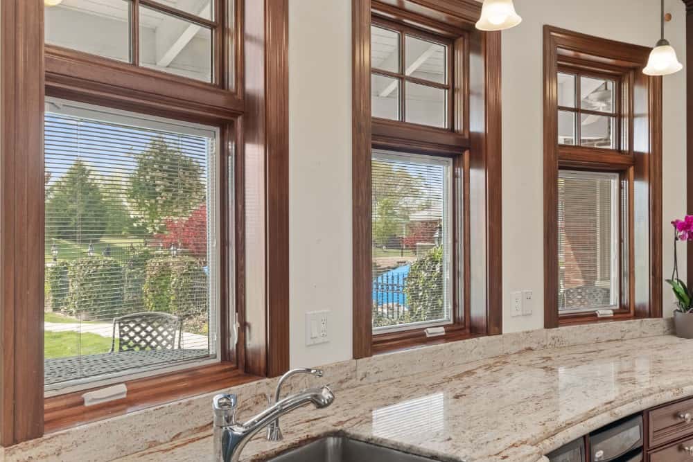 Wooden framed windows above the sink provide amazing views and fresh sunlight into the kitchen. Image courtesy of Toptenrealestatedeals.com.