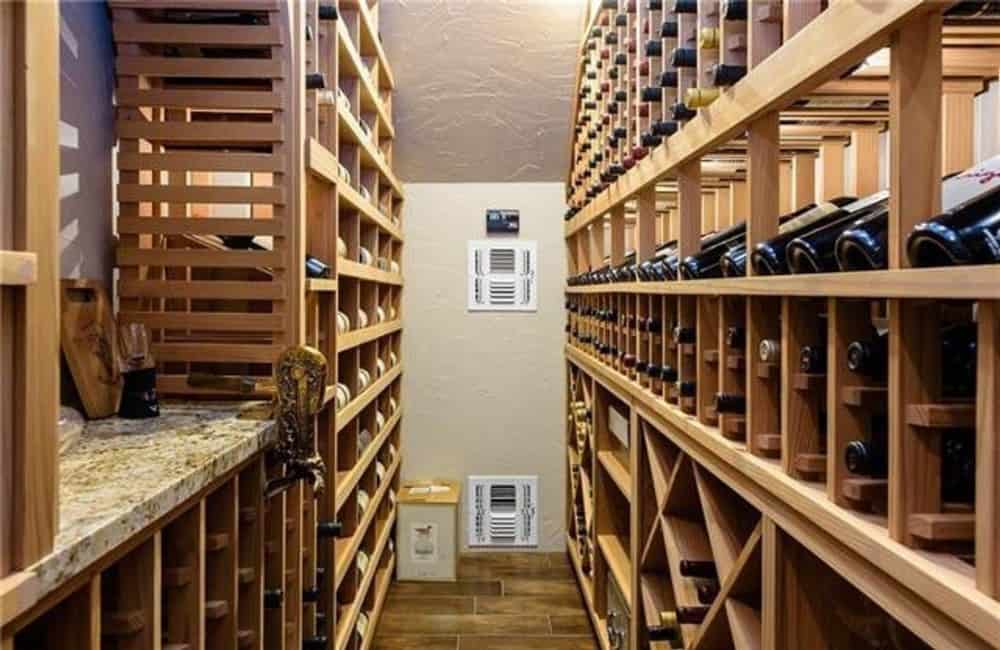 Wine cellar with wooden cubbies and a granite countertop that serves as a serving bar.