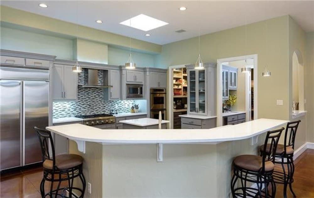 The kitchen offers two islands, white cabinets, a skylight, and a butler's pantry.