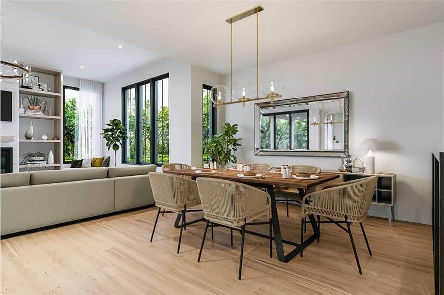 Dining area with wicker round back chairs and a wooden dining table topped with a brass chandelier.