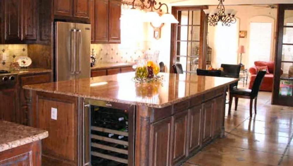 Just across the kitchen is the breakfast area with a round dining set topped with an ornate wrought iron pendant.