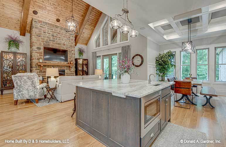 An open layout view of the great room, kitchen, and dining area defined by various ceilings.