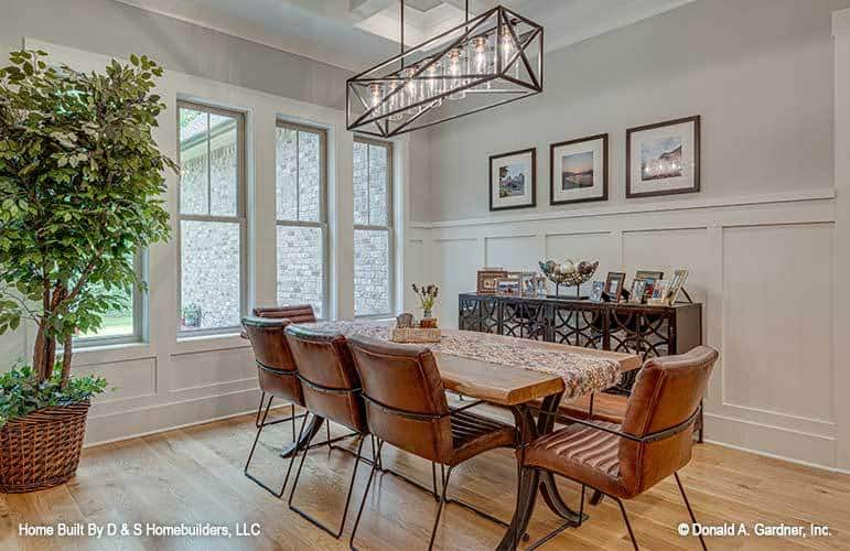Slim windows on one side of a wall bring natural light into the dining area.
