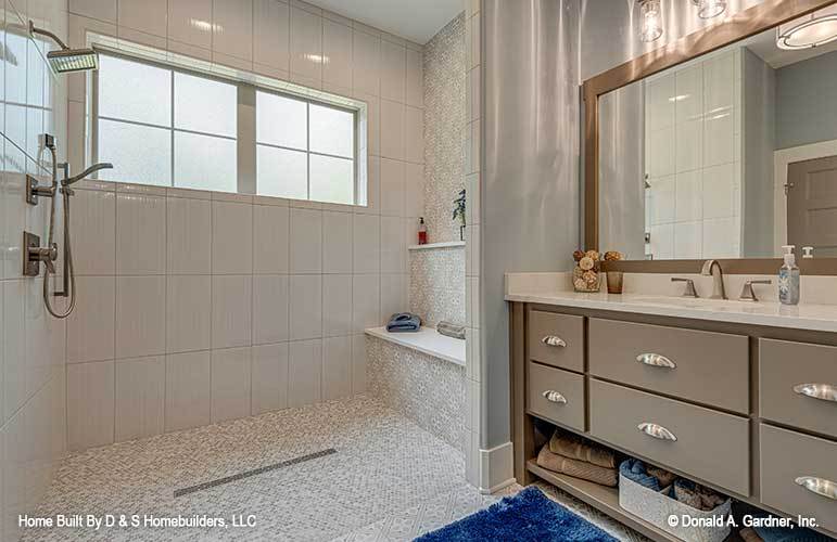 Bathroom with large sink vanity and a walk-in shower equipped with chrome fixtures, a tiled bench, and a built-in shelf.