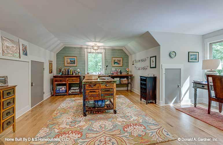 Bonus room with a covered ceiling, distressed cabinets, and a study desk by the dormer window.
