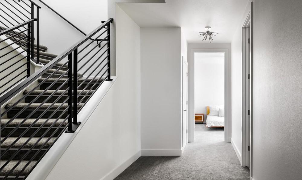 Carpeted staircase leading down the basement. The basement offers two additional bedrooms and a shared bathroom.