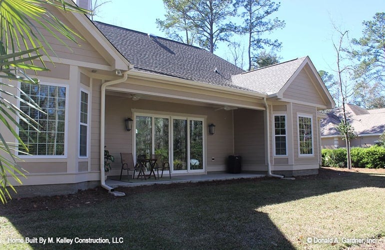 Rear exterior view with a covered porch nestled between the bay windows.