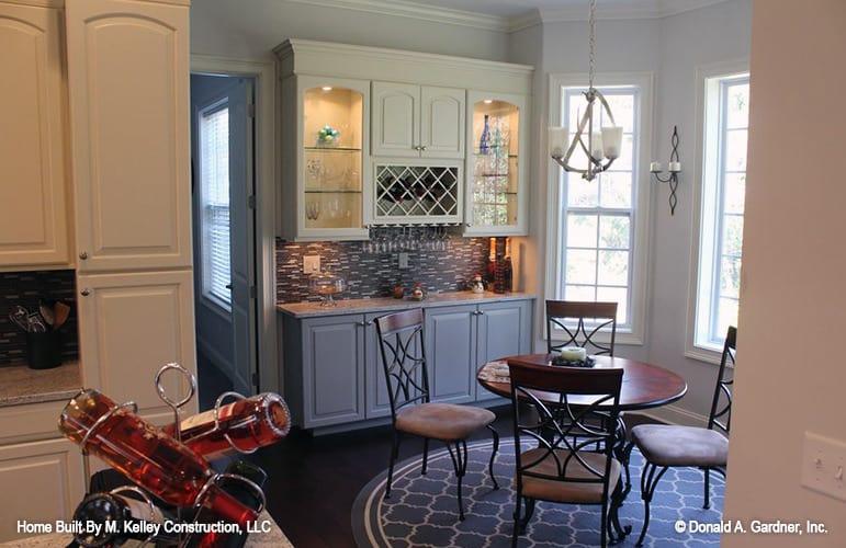 Breakfast area with a bar and 4-seater dining set sitting on a round area rug.