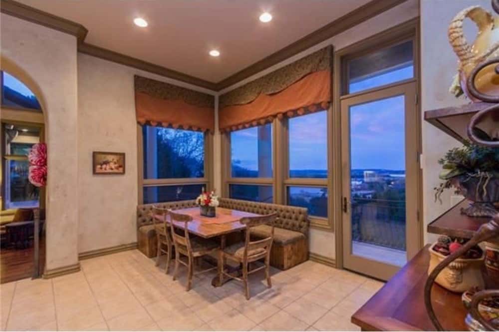 Breakfast nook with a wooden dining set, banquette seating, and a glazed door leading to the covered veranda.