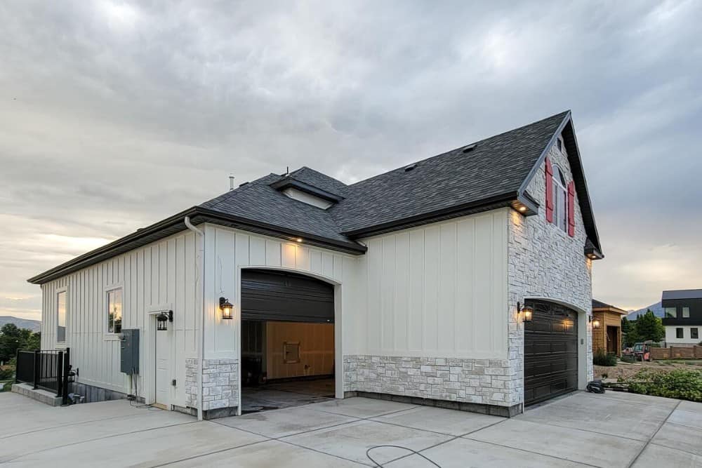 Left exterior view showing the multiple garages enclosed in oversized arched steel doors.