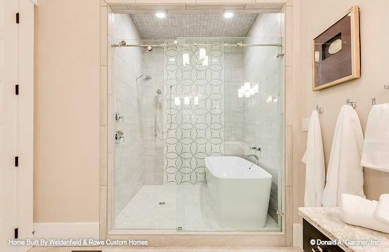 Walk-in shower with sliding glass doors, chrome fixtures, and a freestanding tub.