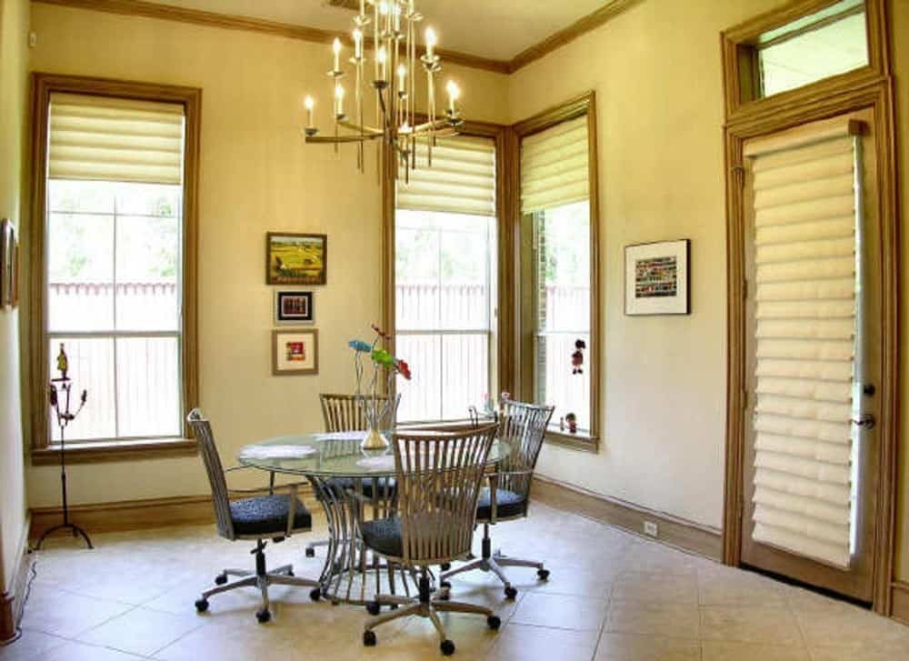 Breakfast nook with a candle chandelier, a round dining set, and tall windows allowing natural light in.