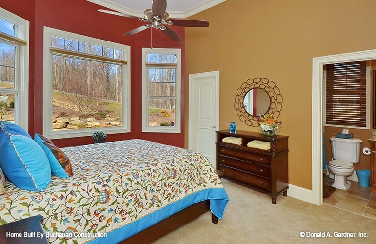 Another bedroom with carpet flooring, multi-colored walls, and a private bathroom.