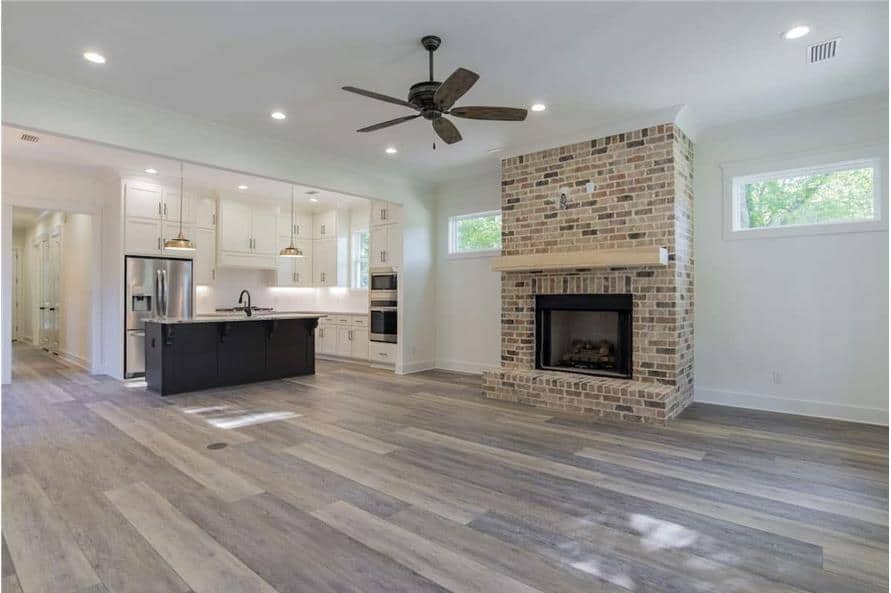 Great room with a brick fireplace, a ceiling fan, and clerestory windows that bring natural light in.
