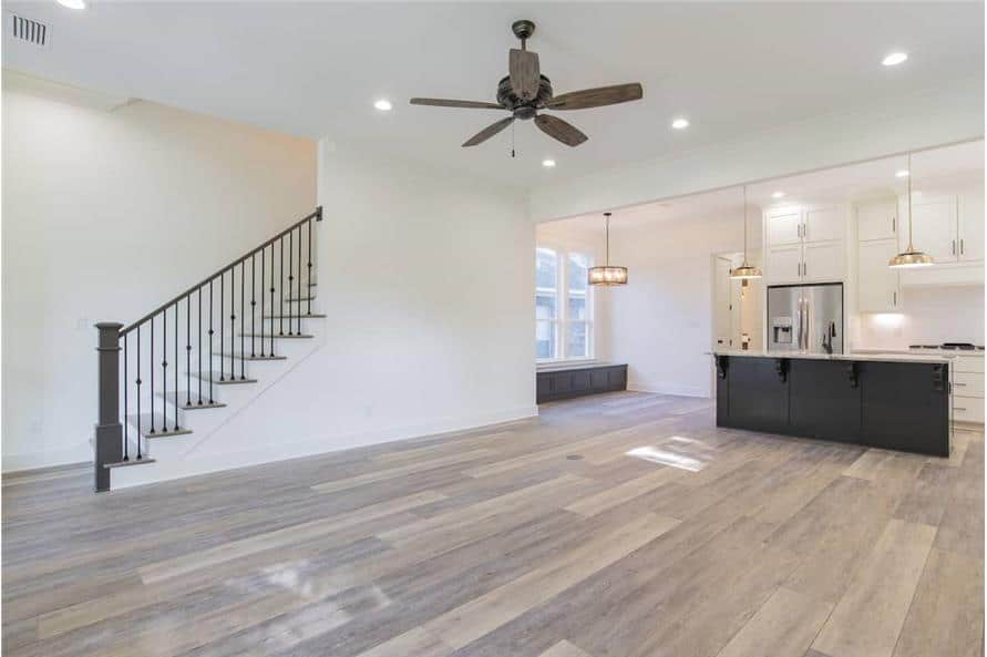 A wooden staircase across the great room framed with wrought iron railings leads to the upstairs bedrooms.