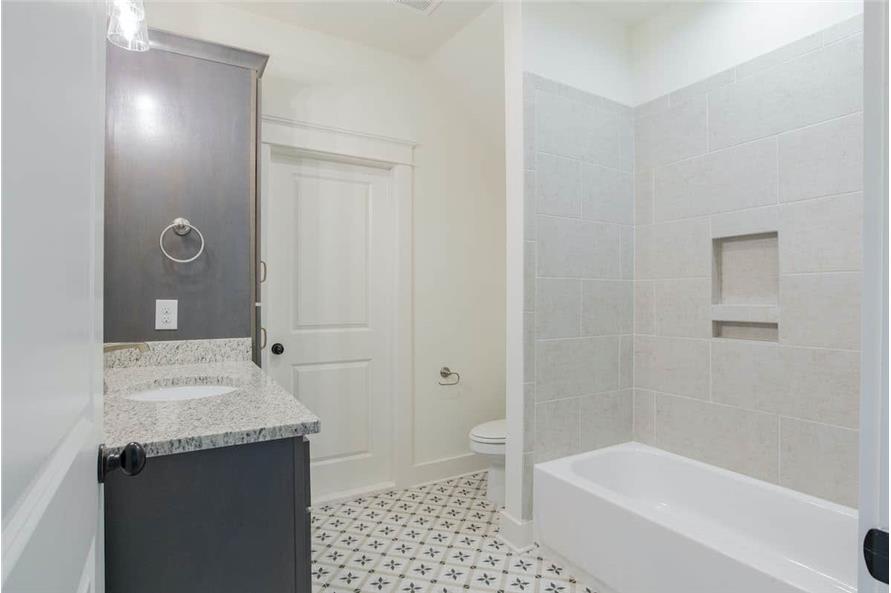 A patterned tile flooring creates interest in this white bathroom.