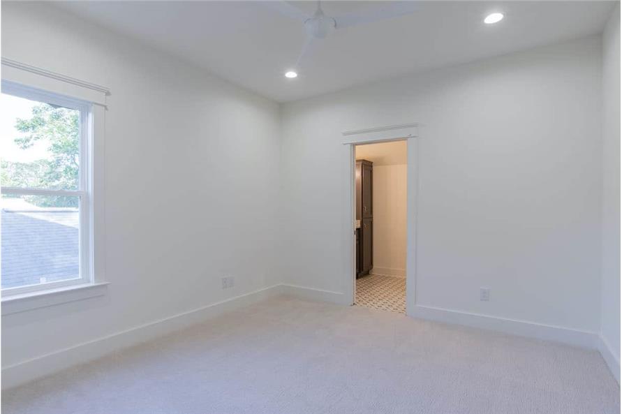 The bedroom includes a private bathroom concealed behind the white door