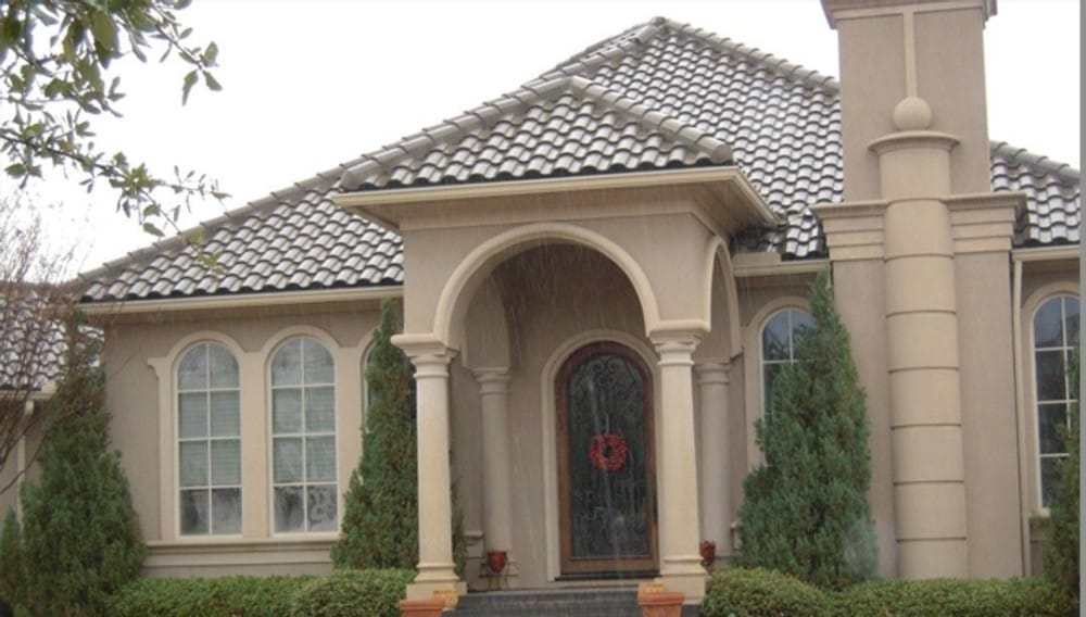 A closer view of the home entry shows its arched front door and decorative arches framing the covered porch.