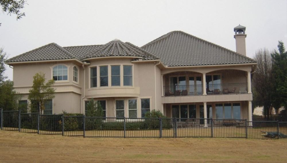 Rear exterior view with covered porches, upper balcony, and a multitude of white-framed windows.