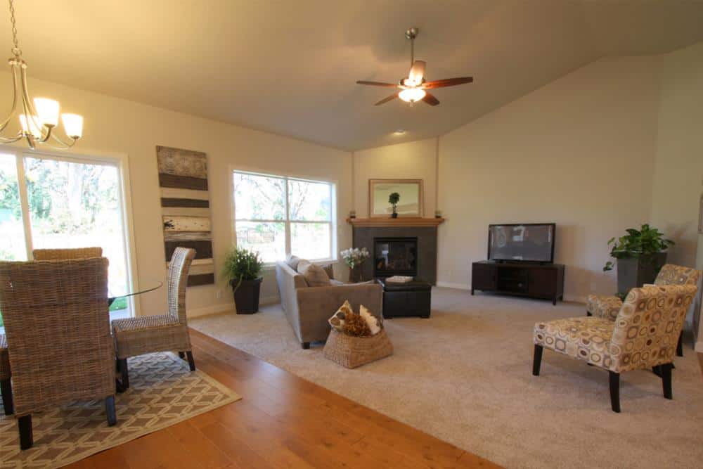 A vaulted ceiling mounted with a ceiling fan crowns the living room.