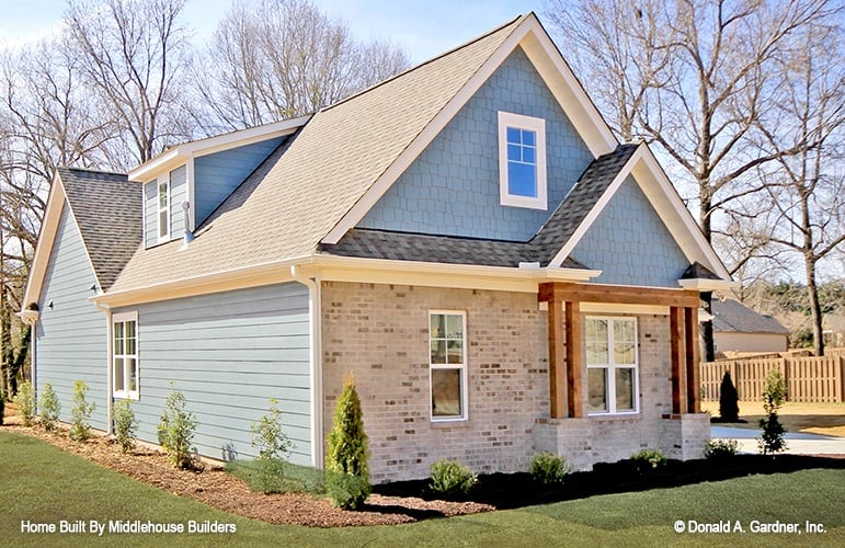 Left exterior view with stone and siding, double columns, and gable roofs accentuated with cedar shakes.
