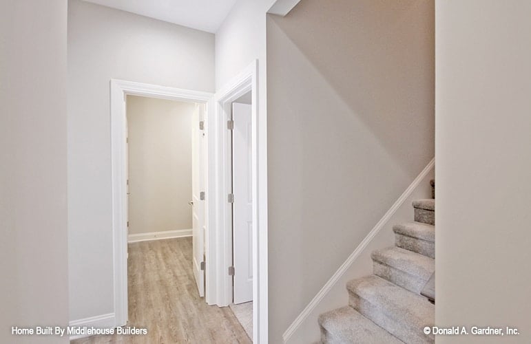 A small hallway with carpeted staircase leading to the upstairs bonus room.