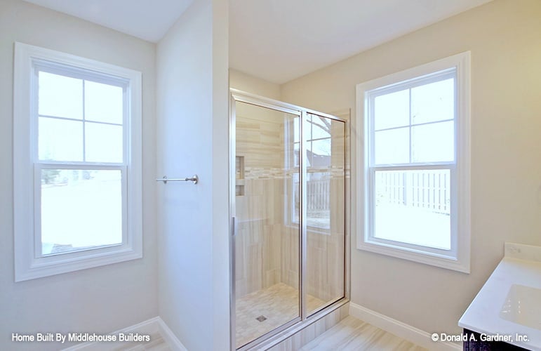 The primary bathroom includes a walk-in shower enclosed with sliding glass doors.