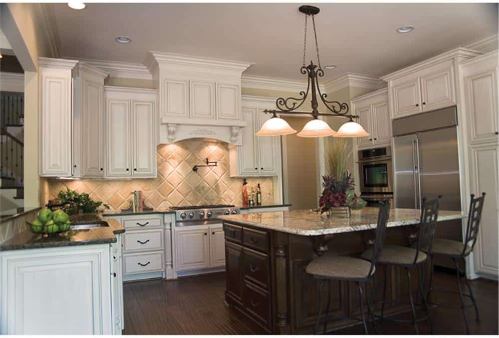 A dark wood breakfast island complemented with cushioned counter chairs and warm pendants completes the kitchen.